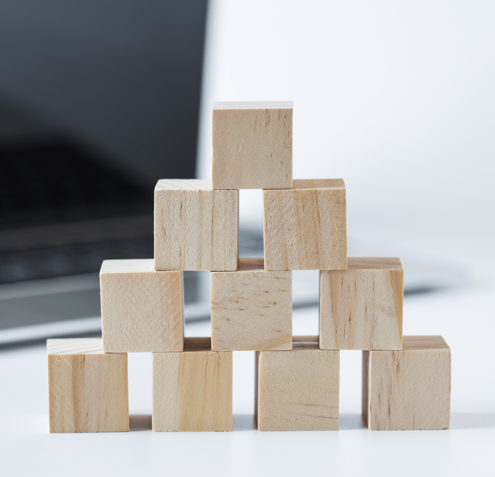Holzbausteine vor einem Laptop symbolisieren die modulare und skalierbare Struktur von Studo Flow zur Digitalisierung der Hochschulverwaltung