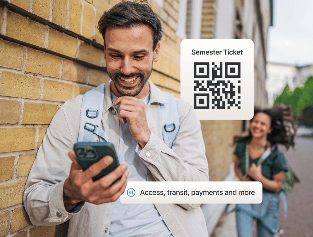 Smiling students walking on a university campus, one holding a smartphone displaying Studo all-in-one digital ID with a QR code for semester ticket identification and a barcode for library access