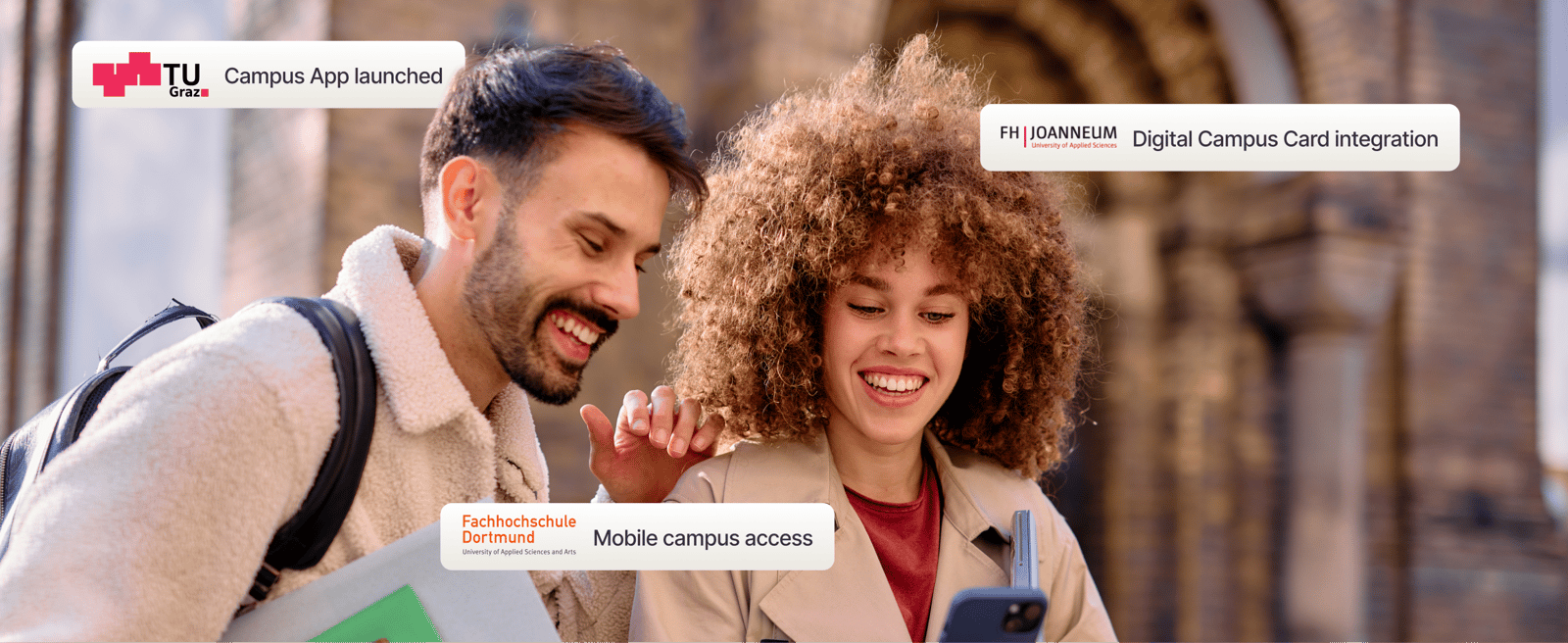 Two smiling university students looking at a smartphone screen in front of a campus building, featuring digital integration updates from TU Graz, FH JOANNEUM, and Fachhochschule Dortmund.