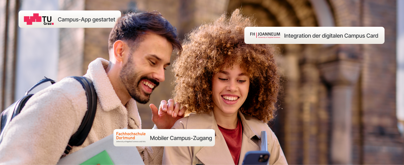 Zwei lächelnde Studierende schauen auf ein Smartphone-Display vor einem Campusgebäude, das digitale Integrations-Updates von TU Graz, FH JOANNEUM und der Fachhochschule D zeigt.